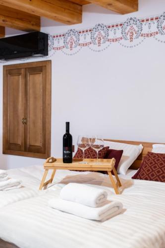 a bed with a table with wine glasses on it at Wellba Homestead Planina in Ajdovščina