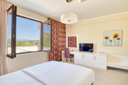 a hotel room with a bed and a window at Hotel Opera Jaz in Budva