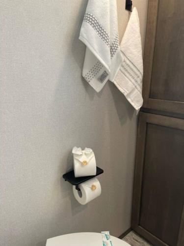 a bathroom with a toilet and towels on a wall at Downtown Dade City Glamper in Dade City