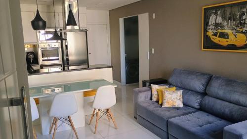 a living room with a blue couch and a table at Comfortable apartment in Alphaville in Barueri