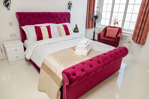 a bedroom with a large bed with a red headboard at G Boutique Hotel in Portsmouth