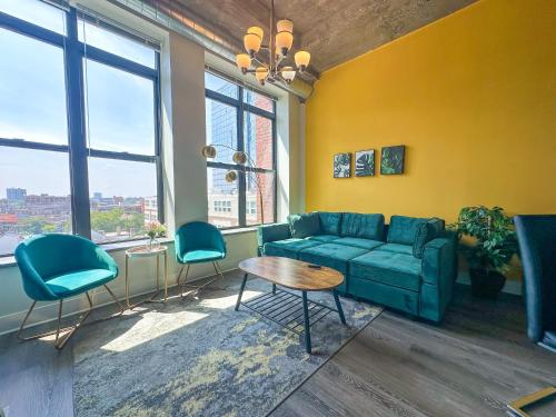 a living room with a blue couch and two chairs at Convenient 2BR Suite in Prime Location with Gym Access & Optional Parking Near McCormick Place and Soldier Field in Chicago