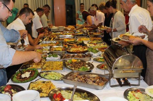 a group of people standing around a table full of food at Hotel Saraj in Sarajevo
