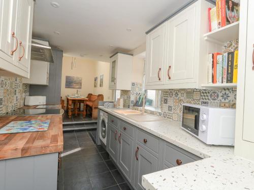 a kitchen with white cabinets and a table in it at Home From Home in Portland