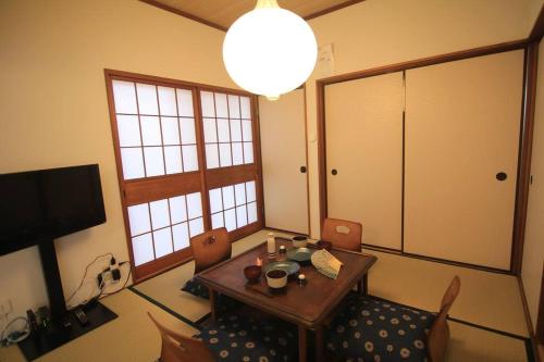 a dining room with a table and chairs and a lamp at 藤沢-鎌倉Home in Fujisawa