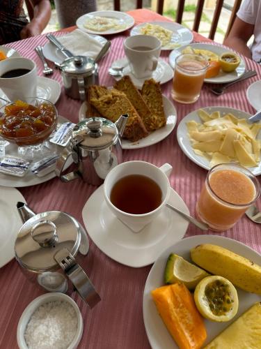 a table with plates of food and a cup of tea at Bernique Guesthouse in La Digue