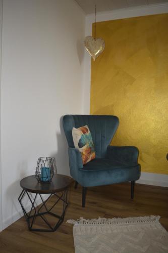 a living room with a blue chair and a table at Chalet Auszeit in Olsberg