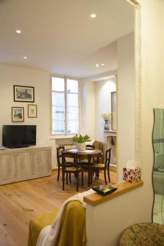 a living room with a table and a dining room at Welcomely - Burlamacchi House in Lucca