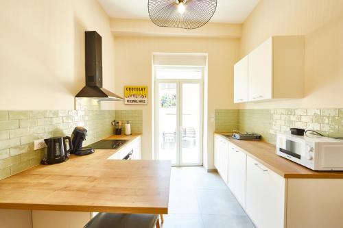 une cuisine avec des armoires blanches et un comptoir en bois dans l'établissement RI 1 - F3 Le Paradis caché à Mulhouse-1 à 5 personnes, à Mulhouse