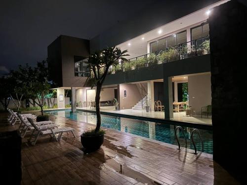 ein großes Haus mit einem Swimmingpool bei Nacht in der Unterkunft panalee banna village独栋东区3卧室别墅Great Value Peaceful Retreat Near7-11 in Nong Prue