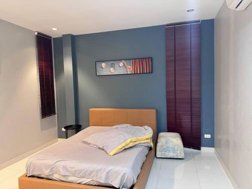 ein Schlafzimmer mit einem Bett mit einer blauen Wand in der Unterkunft panalee banna village独栋东区3卧室别墅Great Value Peaceful Retreat Near7-11 in Nong Prue