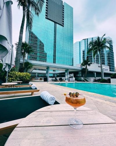 a bowl of fruit sitting on a table next to a pool at Lux Aka Brickell Condo in Miami