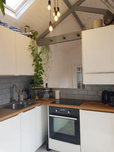 a kitchen with white cabinets and a black oven at Beautiful City Centre Apartment with Cathedral View in St. Albans