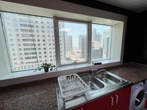 a kitchen with a sink with a view of a city at Top Rated Award Winning 1BR with Sea View in Sharjah