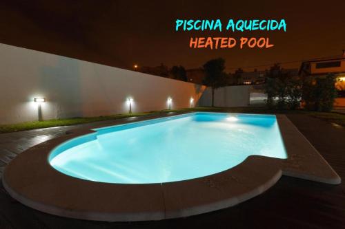 a large swimming pool in front of a building at night at Casa do Cerro in Madalena