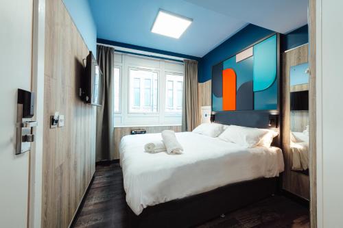 a bedroom with a large white bed with blue walls at Kabannas Newcastle in Newcastle upon Tyne