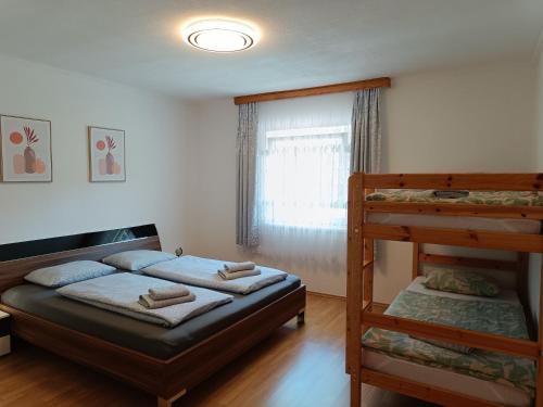 una camera con 2 letti a castello e una finestra di Ella Ferienwohnung ad Arnoldstein