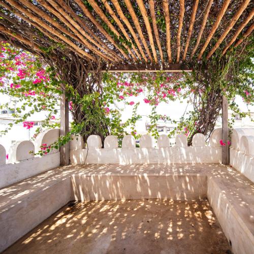 an outdoor altar with white chairs and pink flowers at Authentic Swahili style villa Milele House in Lamu