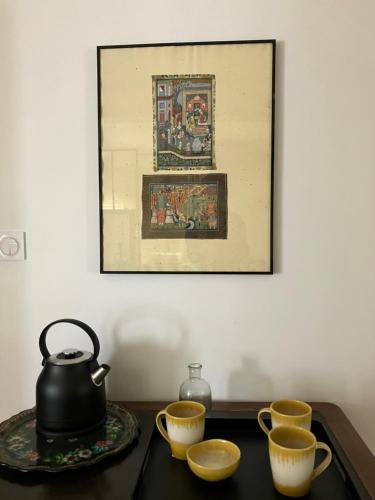 une théière et trois tasses sur une table dans l'établissement Zotheca, à Noyers-sur-Serein