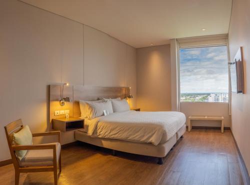 a bedroom with a bed and a large window at Holiday Inn Express Yopal by IHG in Yopal