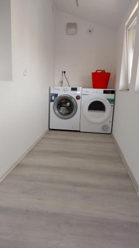 - un lave-linge et un sèche-linge dans une pièce blanche dans l'établissement Apartma VAL - Maribor, à Maribor