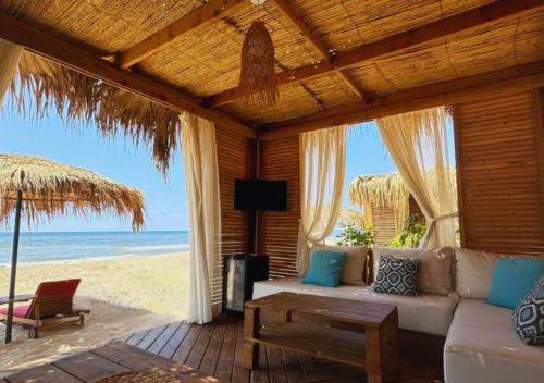 a living room with a couch and a view of the beach at Lancaster Eden Bay in Beirut