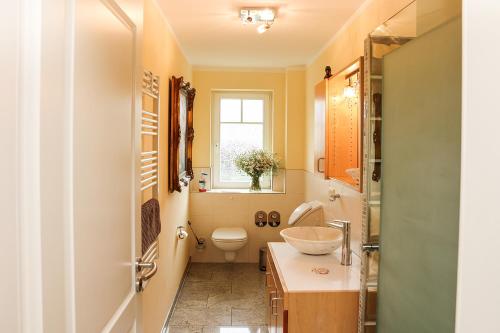 a bathroom with a toilet and a sink at STRANDNAH STRANDLÖWE KÜHLUNGSBORN Ostsee in Kühlungsborn
