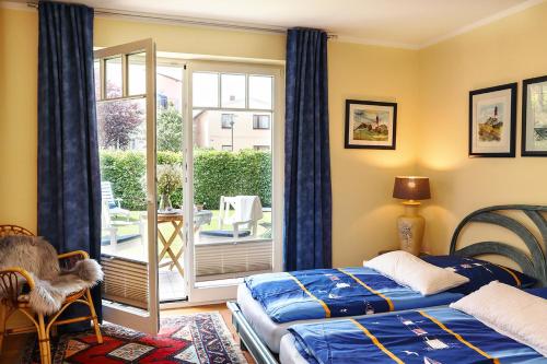 a bedroom with two beds and a balcony at STRANDNAH STRANDLÖWE KÜHLUNGSBORN Ostsee in Kühlungsborn