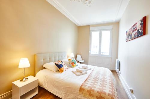 une chambre avec un lit blanc et une fenêtre dans l'établissement RI 2 - F3 Appartement familial spacieux et chaleureux 1 à 6 personnes, à Mulhouse