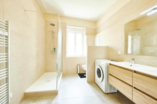 une salle de bain avec une machine à laver et un lavabo dans l'établissement RI 2 - F3 Appartement familial spacieux et chaleureux 1 à 6 personnes, à Mulhouse