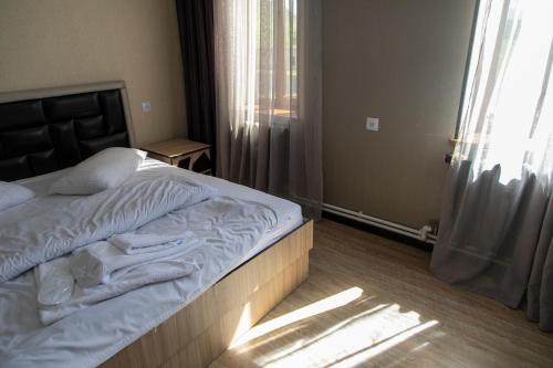 a bedroom with a large bed with a window at Fish Hotel in Akhalk'alak'i