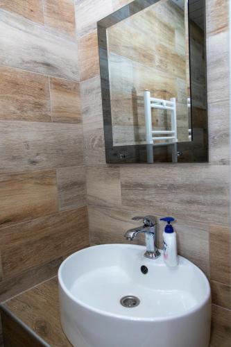 a bathroom with a white sink and a mirror at Fish Hotel in Akhalk'alak'i