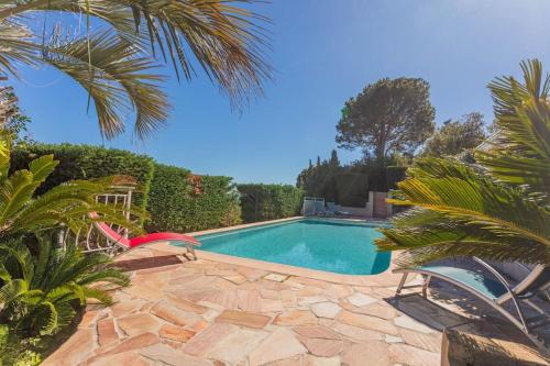 - une piscine dans une cour avec des chaises et des arbres dans l'établissement Villa 197 m2, vue mer, parking, à Roquebrune-sur Argens
