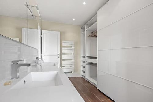 une salle de bain blanche avec un lavabo et un miroir dans l'établissement Villa 197 m2, vue mer, parking, à Roquebrune-sur Argens