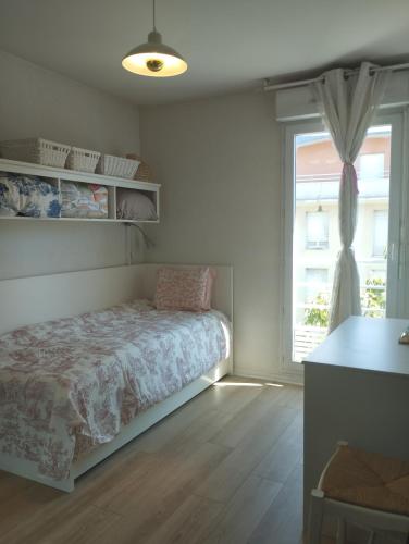 - une chambre avec un lit en face d'une fenêtre dans l'établissement Appartement proche Village Olympique au pied du métro Carrefour Pleyel, à Saint-Denis