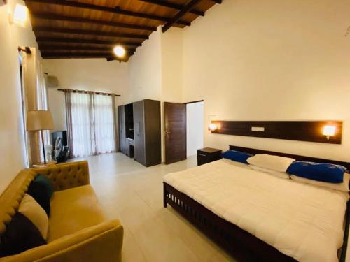 a bedroom with a large bed and a couch at White villa in Ragama