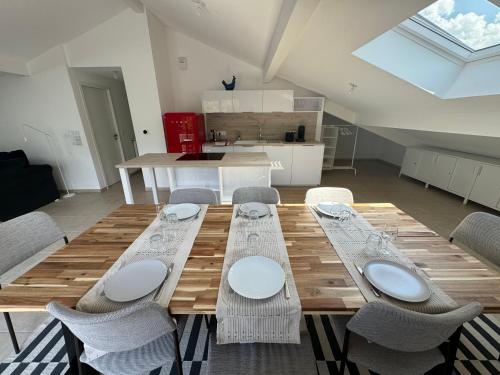 a wooden table and chairs in a room at La cascade du Lac d'Annecy in Doussard