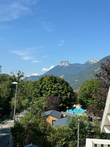 a view of a resort with mountains in the background at La cascade du Lac d'Annecy in Doussard