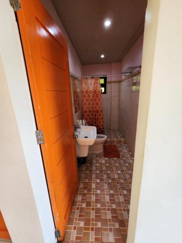 a bathroom with a toilet and a sink at Islandview Whitehouse - Camotes in Esperanza