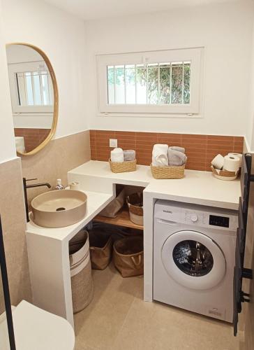 une salle de bain avec une machine à laver et un lavabo dans l'établissement Hyères entre centre ville et plage, à Hyères