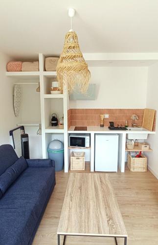 un salon avec un canapé bleu et une table dans l'établissement Hyères entre centre ville et plage, à Hyères