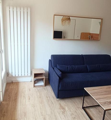 un canapé bleu dans un salon avec un miroir dans l'établissement Hyères entre centre ville et plage, à Hyères