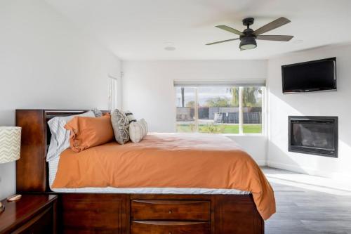 Un dormitorio con una cama y un ventilador de techo. en Private Desert Pool Hot Tub BBQ, en Indio