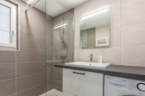 une salle de bain avec un lavabo et une douche en verre dans l'établissement Beau 40m2, Proche du centre, à Saint-Raphaël