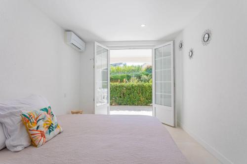 - une chambre blanche avec un lit et une porte ouverte dans l'établissement Beau 40m2, Proche du centre, à Saint-Raphaël