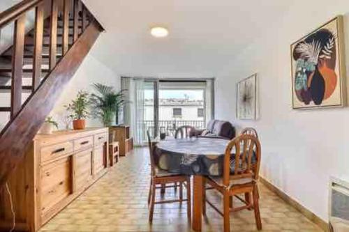 une cuisine avec une table à manger et un escalier dans l'établissement Le Corail du BOUCANET T4 de 70m2 en Duplex avec balcon et parking, au Grau-du-Roi