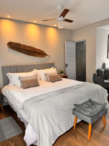 a bedroom with a large bed with a ceiling fan at La Estância Flats in Iguape