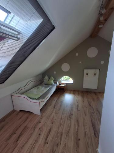 a attic bedroom with a bed and wooden floors at Ferienhaus Mühlfeldner in Laufen