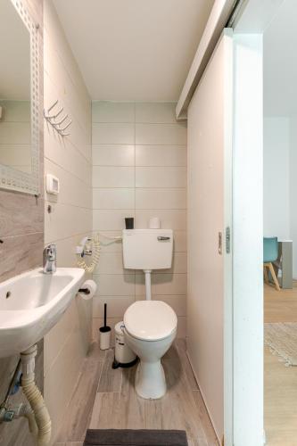 a bathroom with a white toilet and a sink at Haifa Hadar Urban Apartment in Haifa