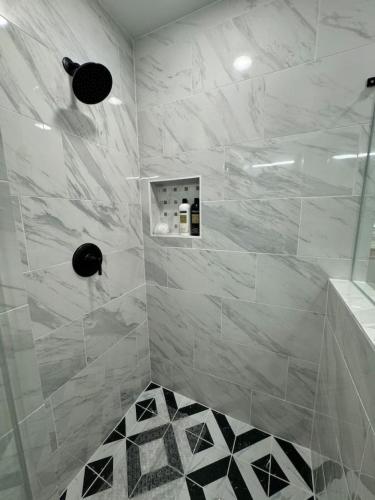 a bathroom with a shower with white marble tiles at Spacious 1 Bdrm Studio Montrose in Houston